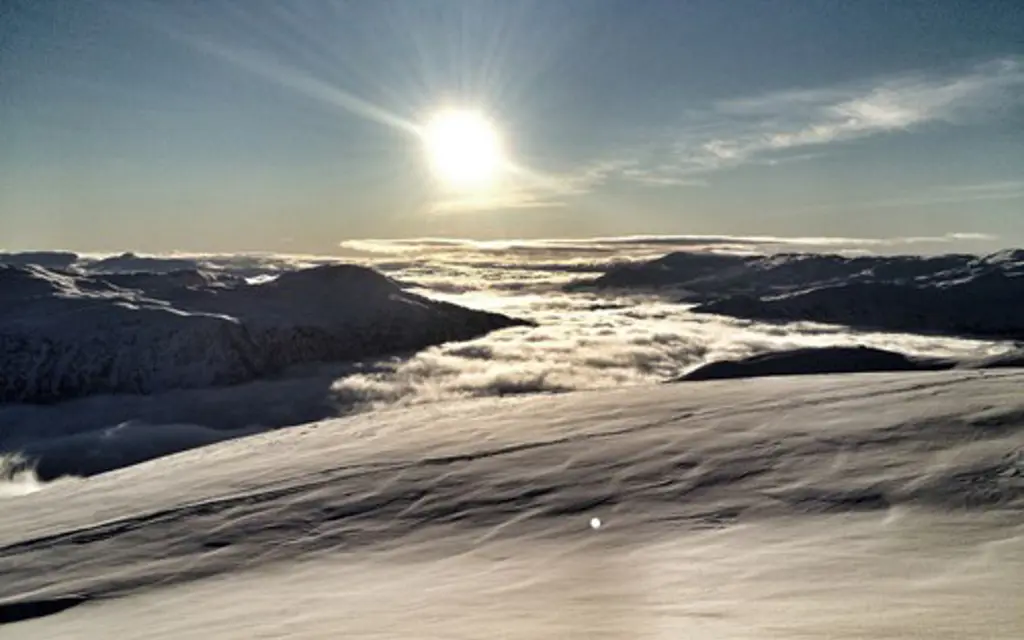 Solskinn over vinterlandskap på fjellet
