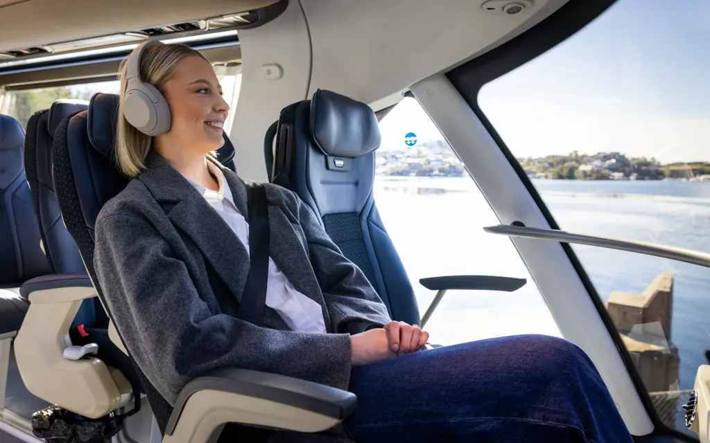 Smiling woman sitting in a panoramic seat on a NOR-WAY bus