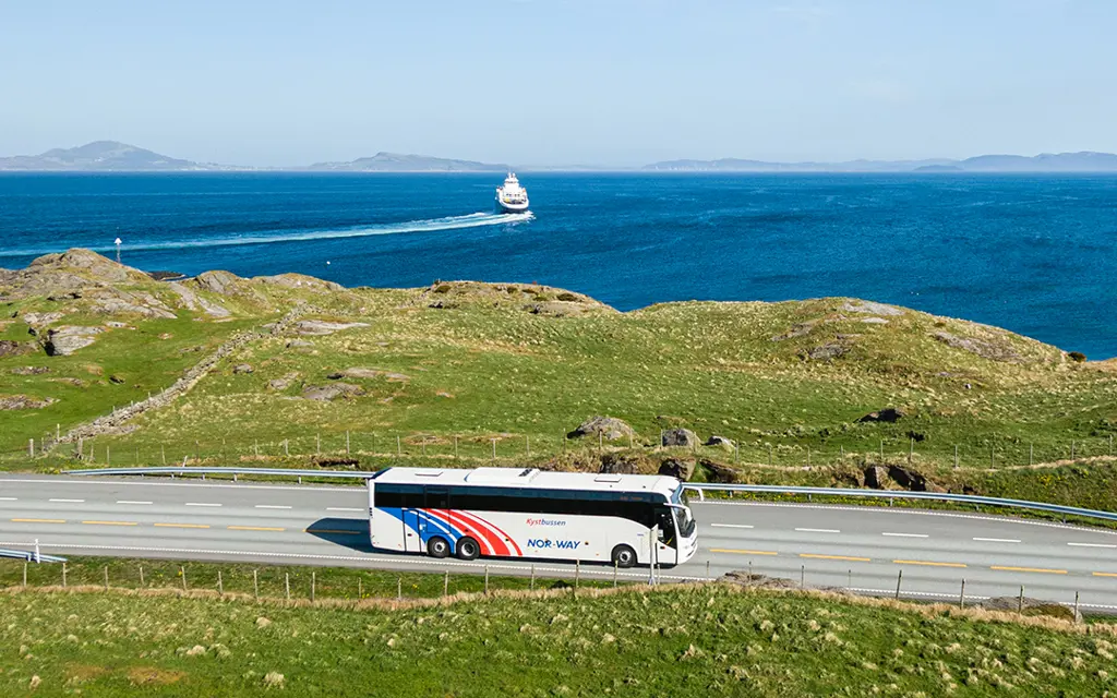 Buss kjører langs kystlandskap