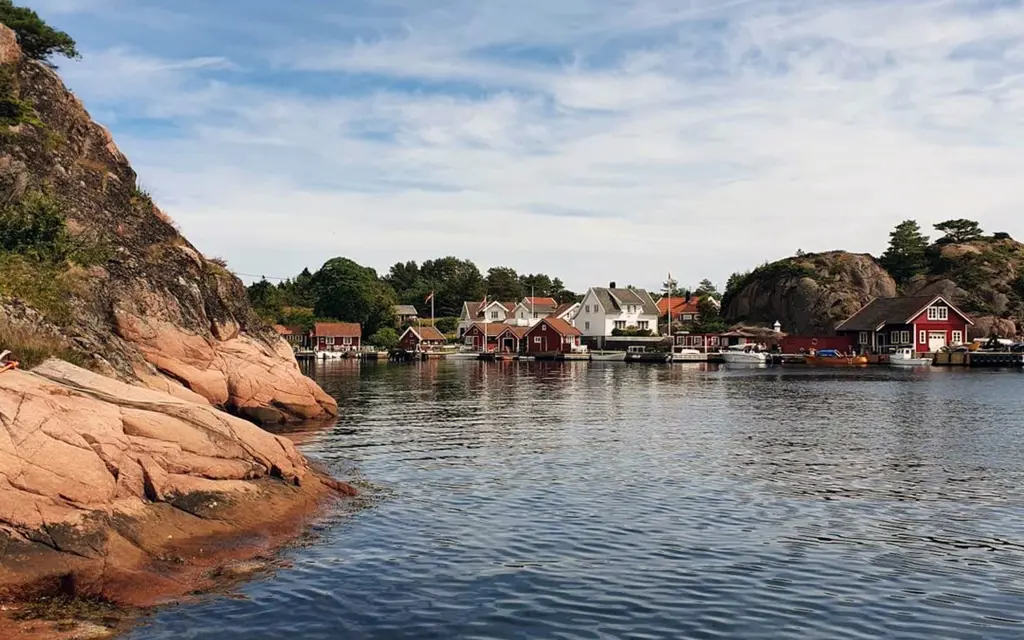 Hus og sjøhus ved vannkanten i Grimstad