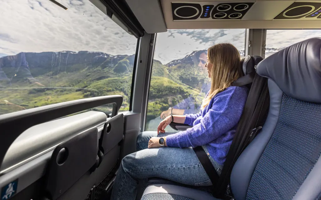 Jente sitter på NOR-WAY buss og ser ut vinduet