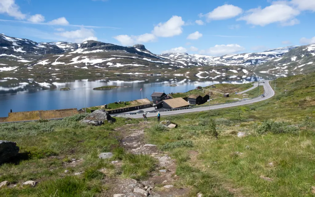 utsikt nedover fra fjellet mot haukeliseter og veien som går forbi med vann og fjellheim i bakgrunnen