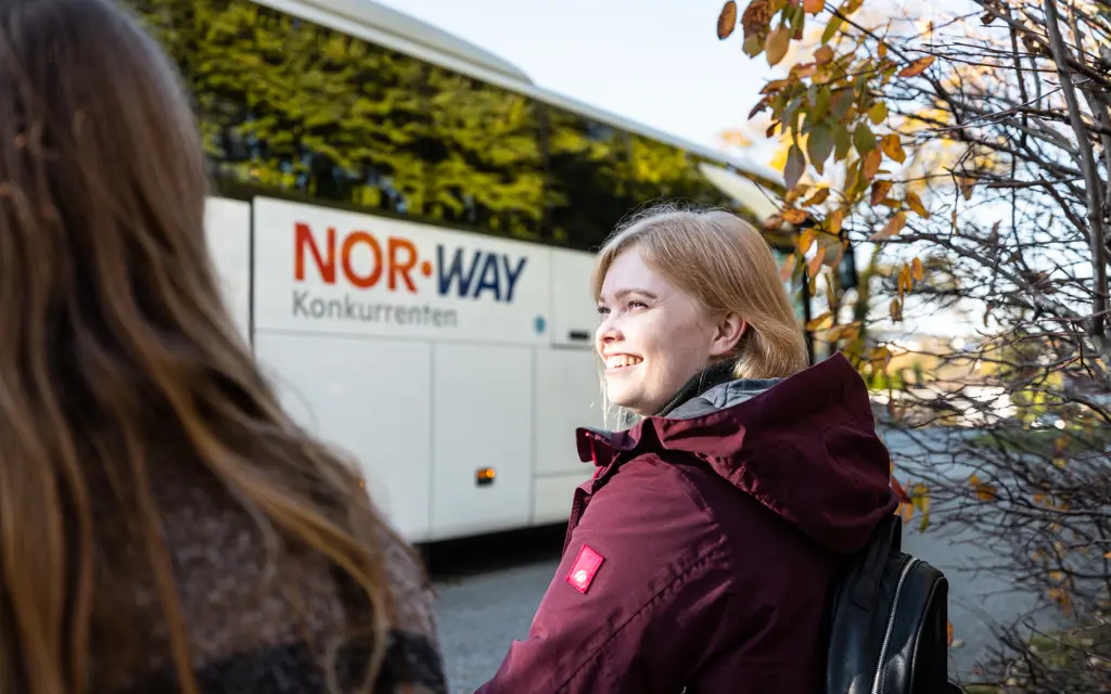 Jenter sitter utenfor NOR-WAY-buss