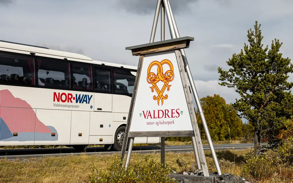 Bilde av buss foran Valdres-skilt