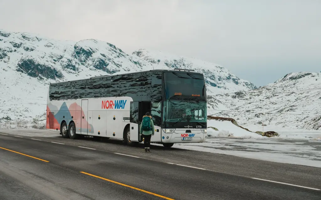 Haukeliekspressen med snødekket fjellandskap i bakgrunnen