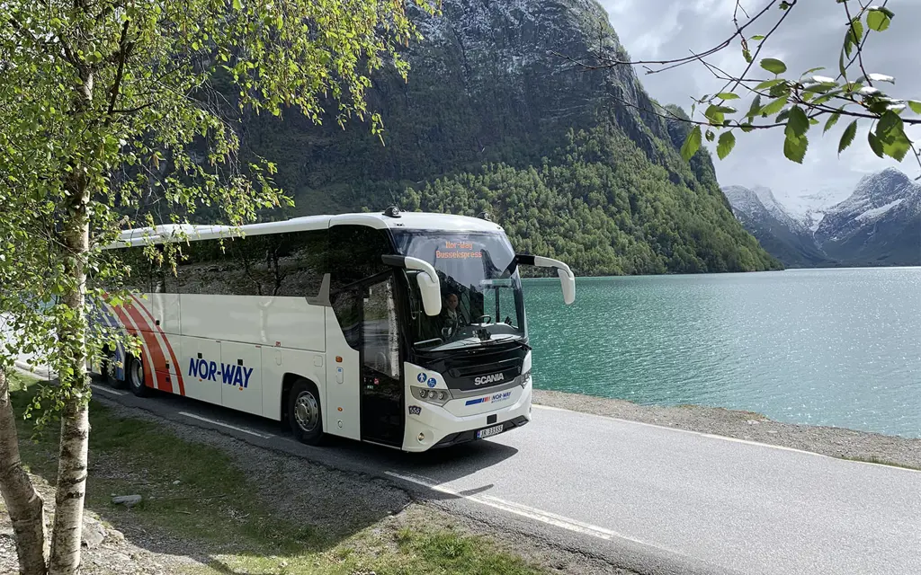 Buss foran fjordlandskap