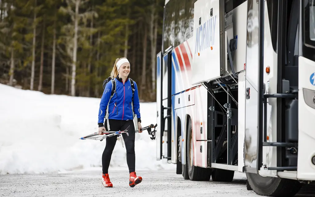 Girl on her way to the bus with skis