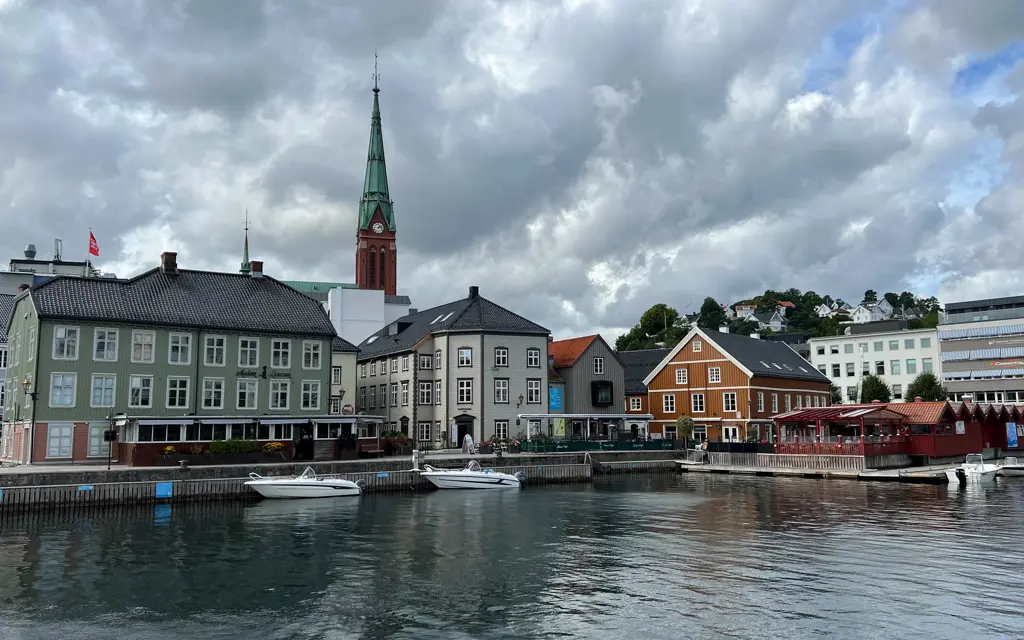 Urban development along the waterfront with boats in the foreground in Arendal